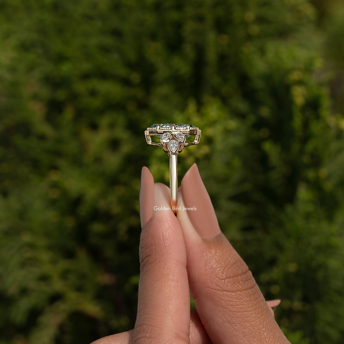 Blue moissanite oval engagement ring with round side stones, open gallery setting