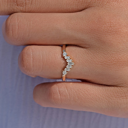 Curved wedding band ring with staggered baguette-cut stone row, close-up on finger