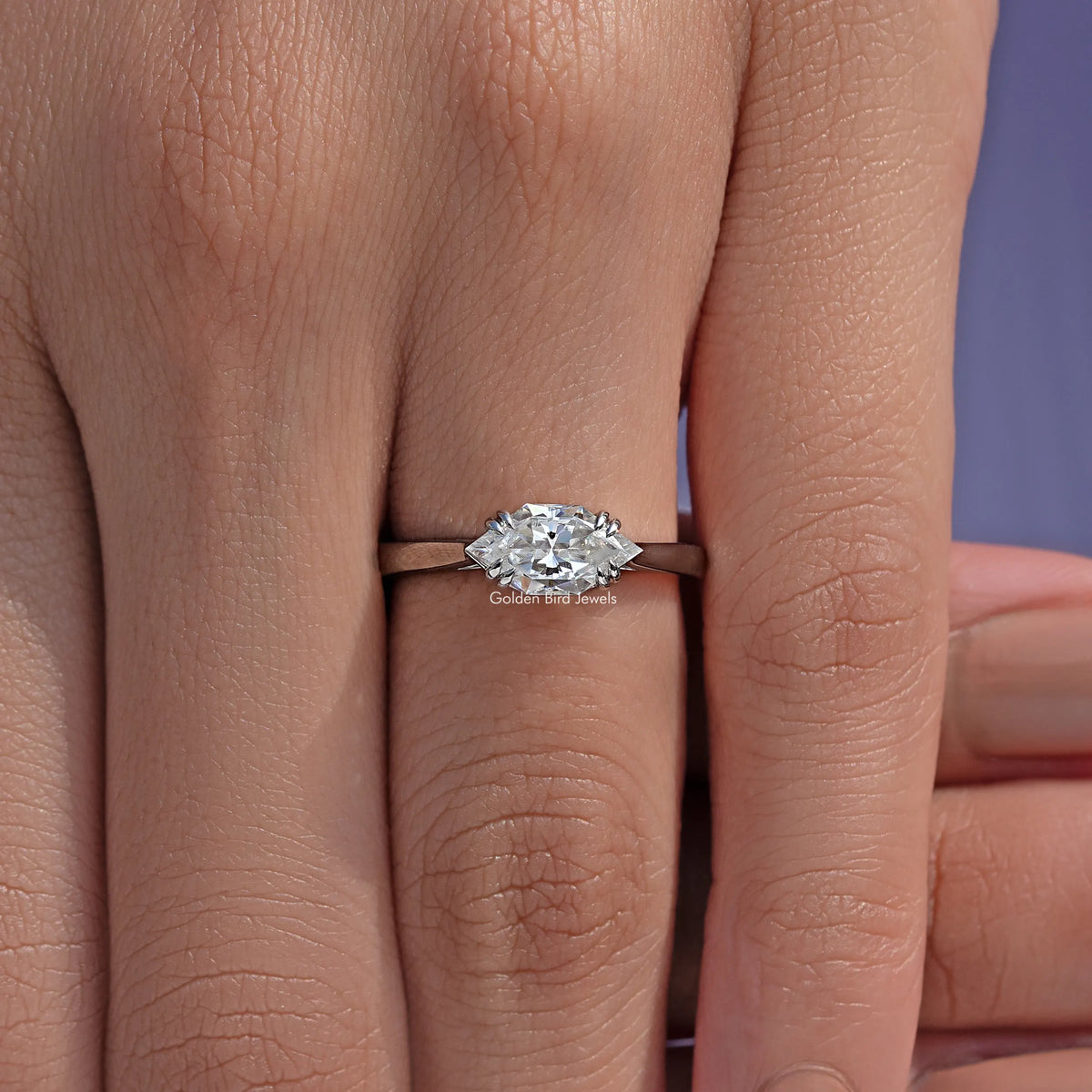 East-west marquise solitaire ring with clear center stone held by small prongs
