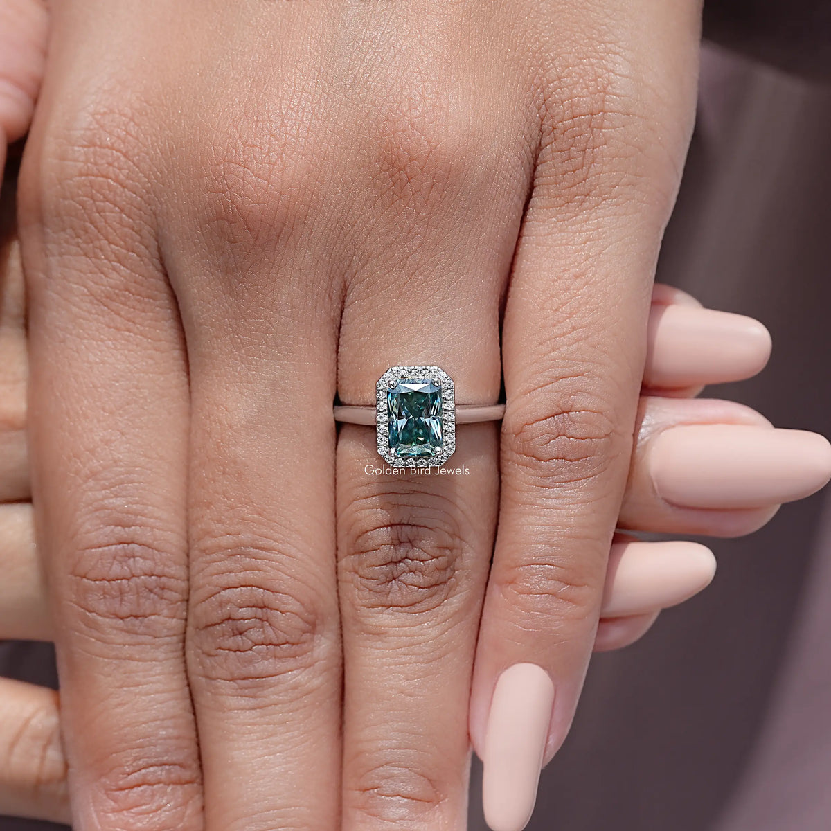 Sterling silver ring with emerald-cut blue moissanite center and diamond halo