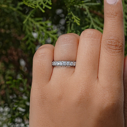 Moissanite eternity band with pave-set round stones on a finger