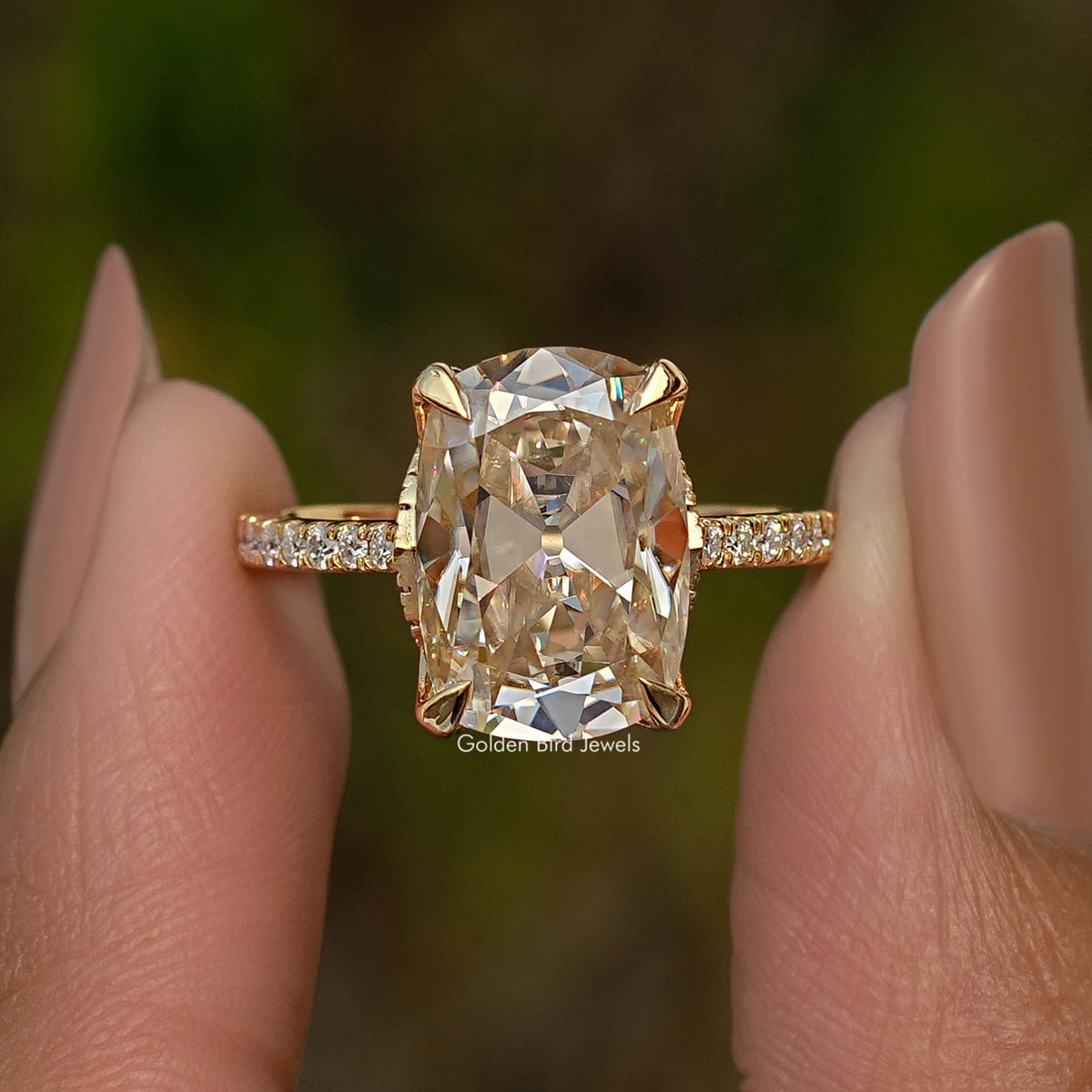 Elongated cushion center engagement ring with hidden halo and baguette side stones