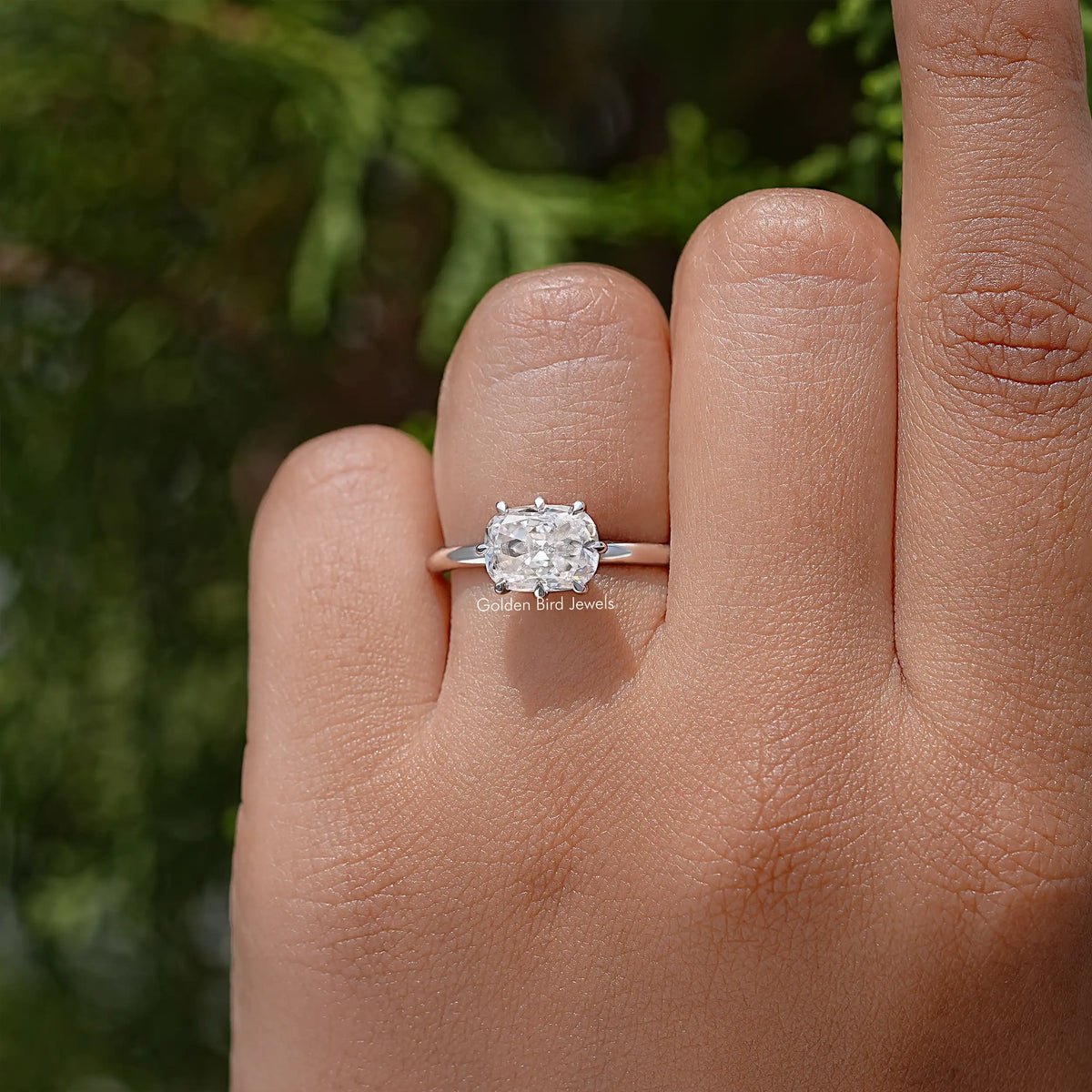 Silver cushion-cut moissanite ring with simple band on open hand