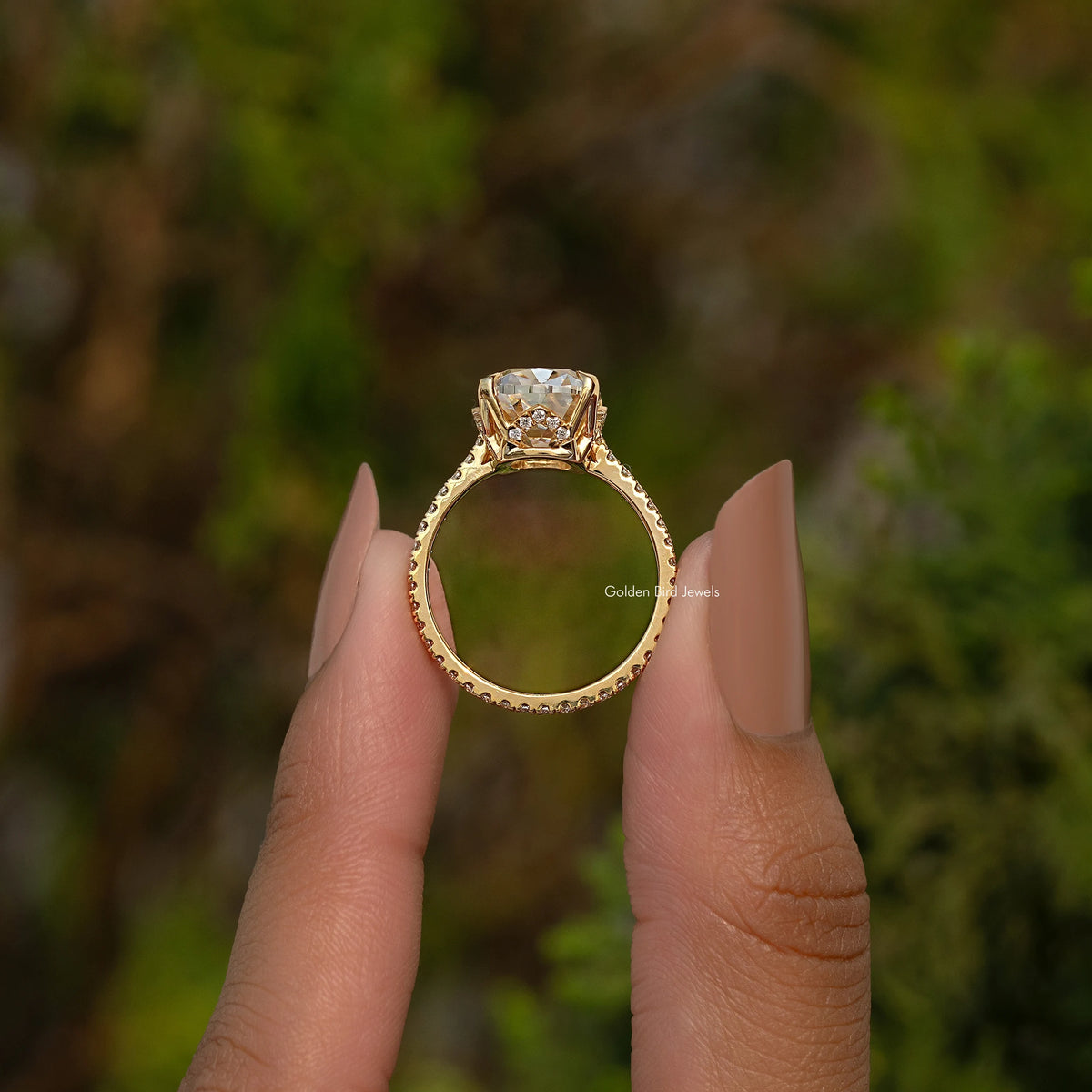 Elongated cushion engagement ring with hidden halo, gold-tone band, oval center stone