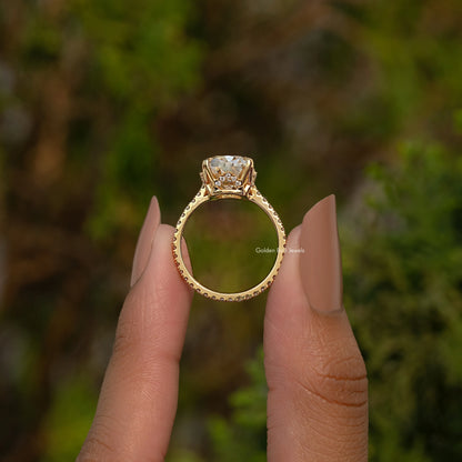 Elongated cushion engagement ring with hidden halo, gold-tone band, oval center stone