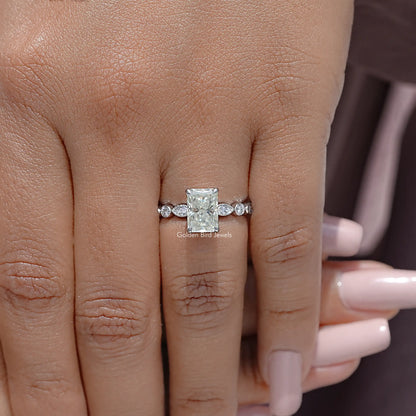 Radiant cut moissanite engagement ring, square center with small side accents, on finger