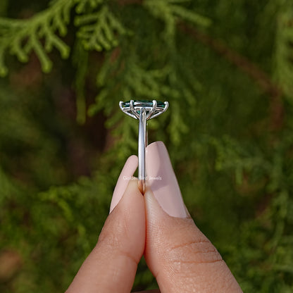 Side view of silver solitaire ring with marquise teal gemstone center