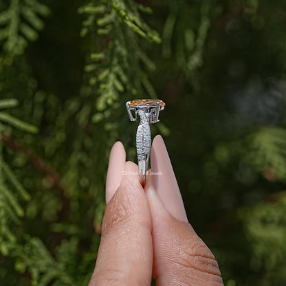 Pear moissanite ring with twisted pavé shank, shown in side view