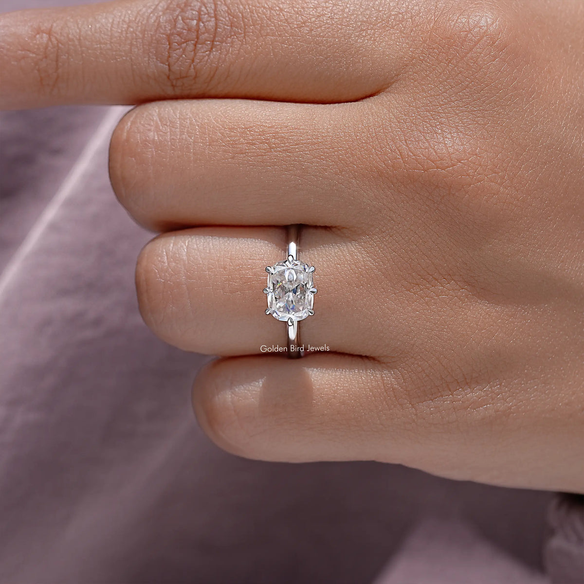 Silver cushion-cut moissanite ring shown from top on fingertip