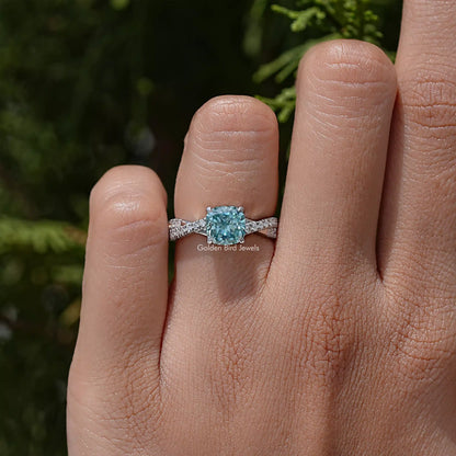 Moissanite engagement ring with twisted band and blue cushion center stone