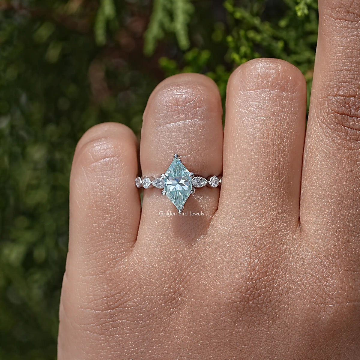 Sterling silver engagement ring with blue marquise center and three-stone side diamonds