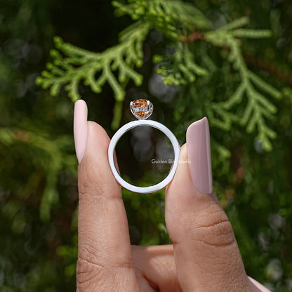 Silver ring side view showing round halo accents under marquise orange center