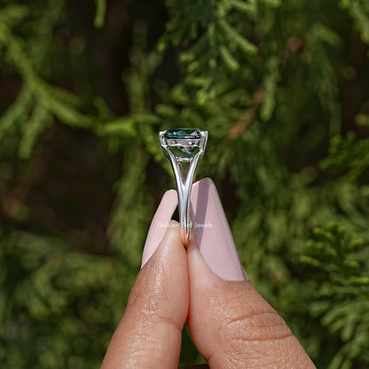 Heart-cut moissanite wedding ring with teal center stone, split shank prongs—close-up