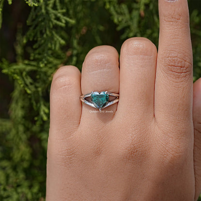 Sterling silver heart-cut moissanite wedding ring on finger, split shank, teal stone