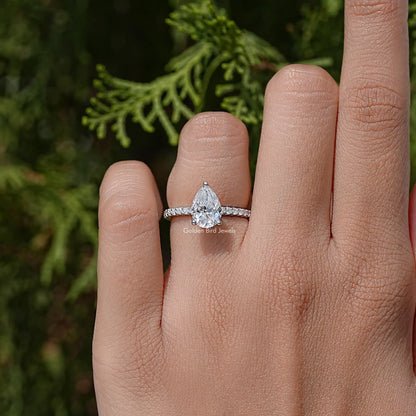 Pear-cut solitaire accent wedding ring on a hand