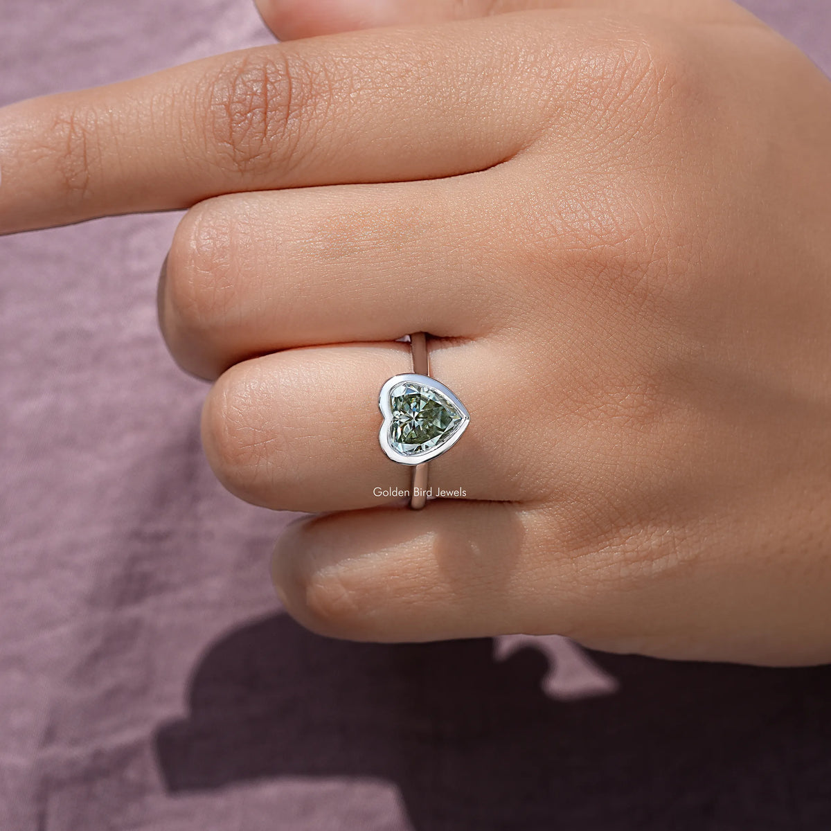 Heart-shaped moissanite bezel ring, close-up of heart stone on sterling band
