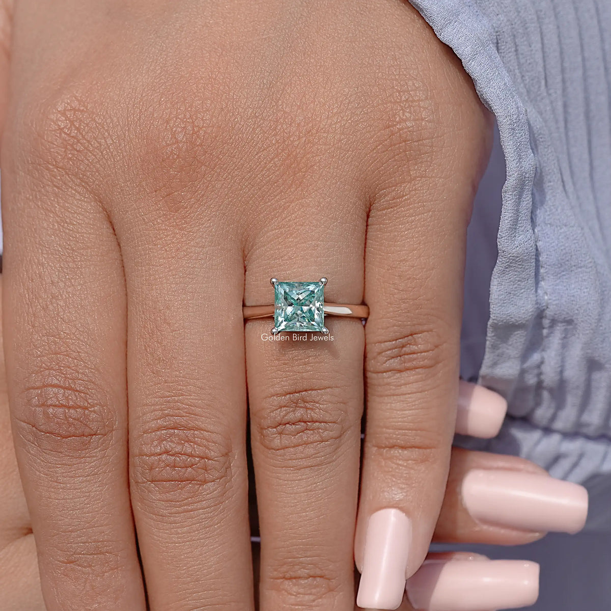 Silver moissanite solitaire ring with square light-blue princess-cut center stone, side view