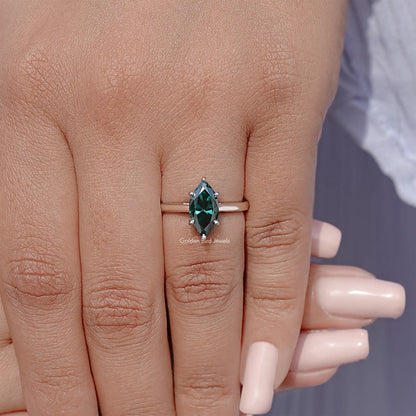 Marquise teal gemstone solitaire ring in silver setting on finger