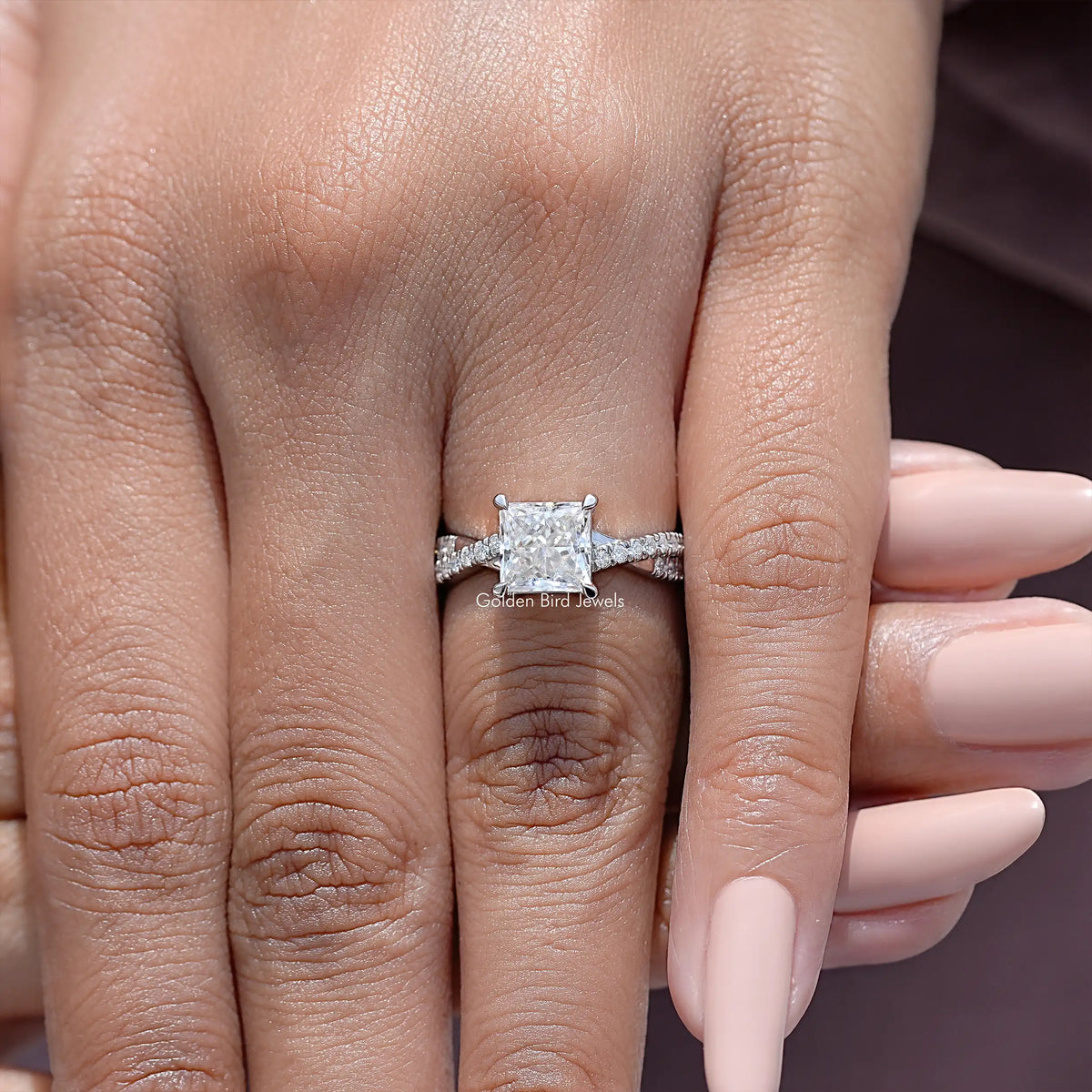 Close-up of sterling silver ring with princess-cut moissanite square center and side stones