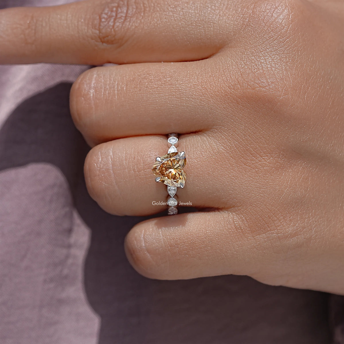Heart-shaped moissanite center stone with small round stones in a sterling silver band