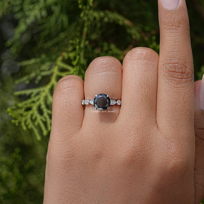 Moissanite engagement ring with dark center stone and side stones on a silver band