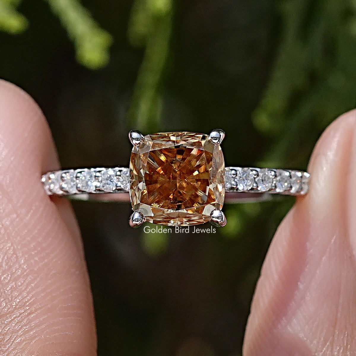 Moissanite engagement ring with cushion-cut amber center stone and pavé band