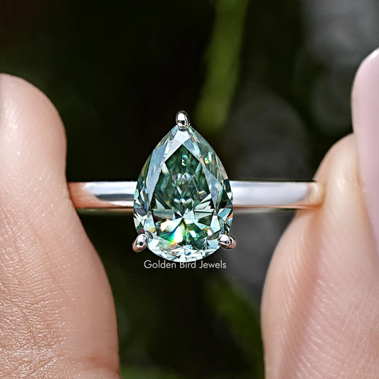 Sterling silver pear-shaped moissanite ring with green stone and side prong view