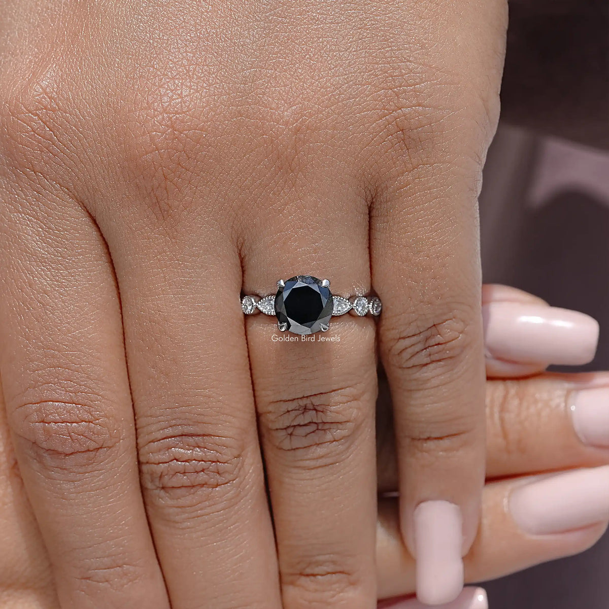 Round-cut moissanite engagement ring with pavé band and halo setting on a hand