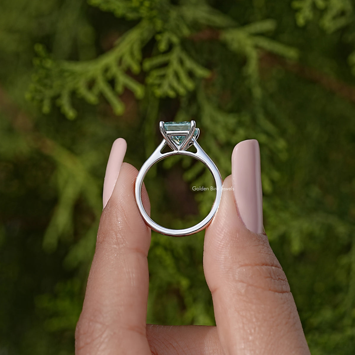 Silver moissanite ring with square light-blue stone in a high, open setting