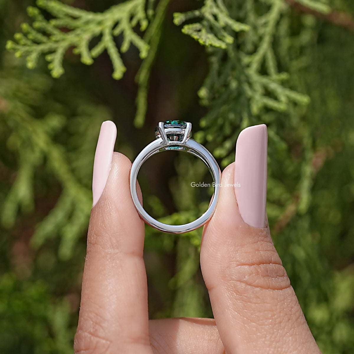 Underside view of sterling silver split-shank engagement ring with round teal moissanite