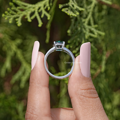 Underside view of sterling silver split-shank engagement ring with round teal moissanite
