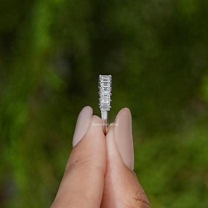 Silver baguette-cut half-eternity band, front view held between fingers