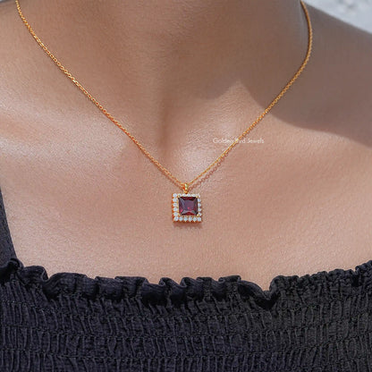 Square ruby-red gemstone pendant with halo detail on gold chain necklace