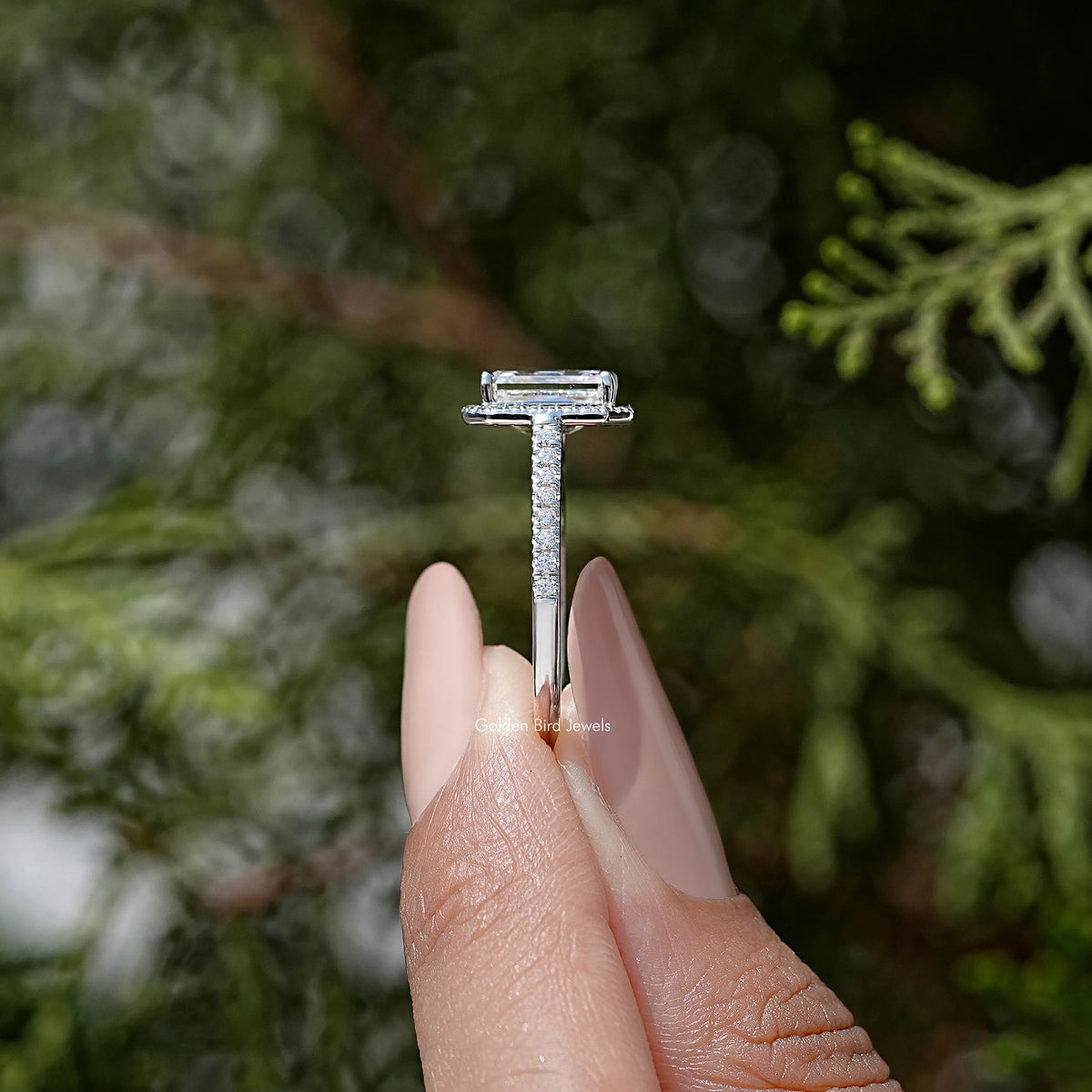 Sterling silver moissanite solitaire ring with emerald-cut center stone, prong-set.