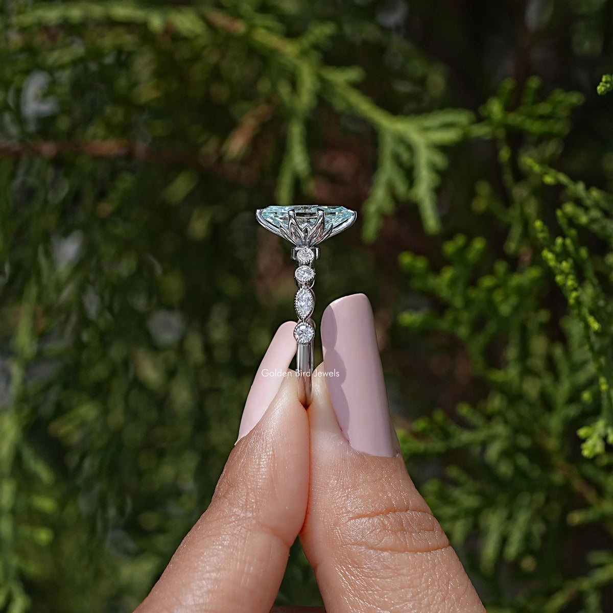 Sterling silver engagement ring with blue marquise center and vertical drop-like stones