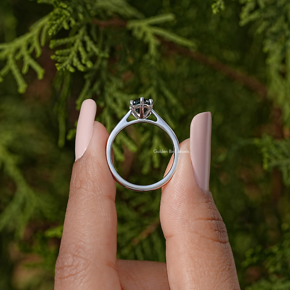 Silver solitaire ring showing round band profile and marquise teal gemstone