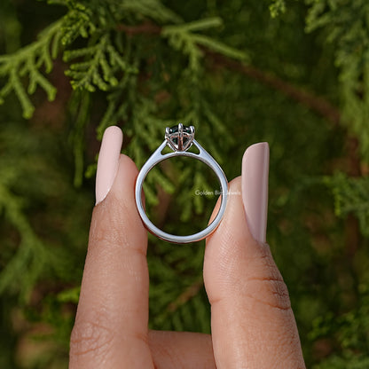 Silver solitaire ring showing round band profile and marquise teal gemstone