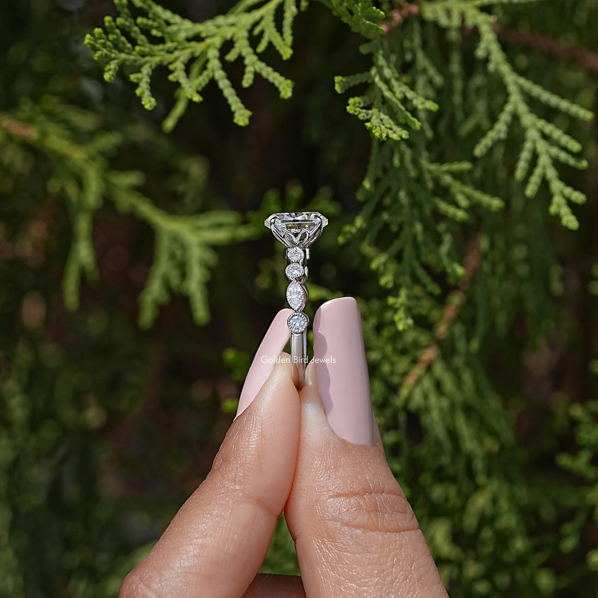 Side view of sterling silver oval moissanite ring with prong-set center and round stones