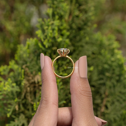 Gold-tone cushion solitaire ring with halo-like prongs, center stone, side view on hand