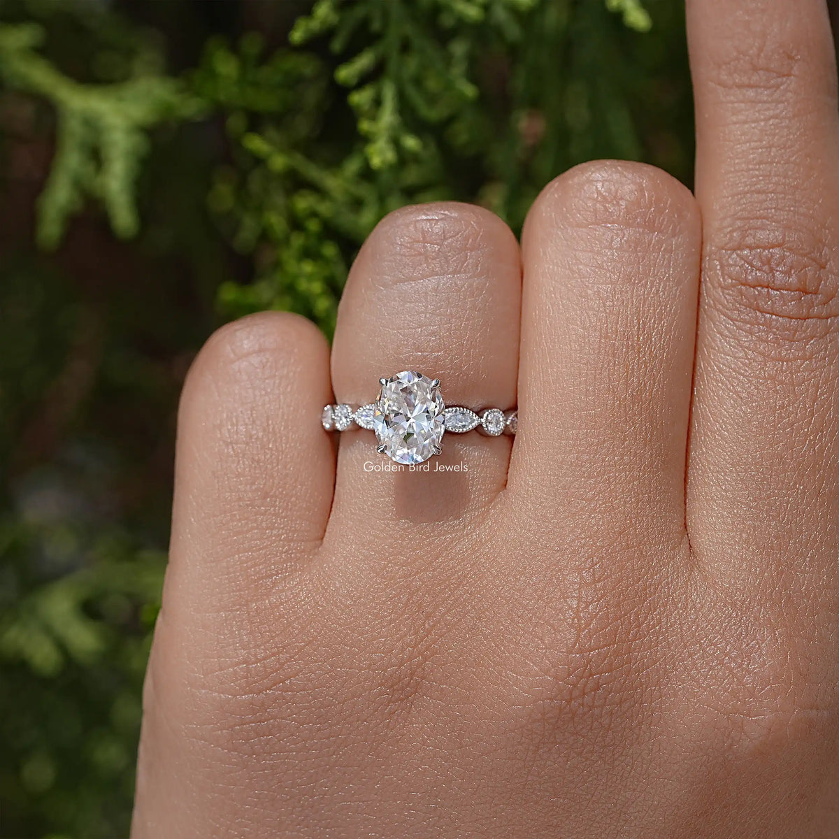 Oval moissanite ring with small round side accents, sterling silver band