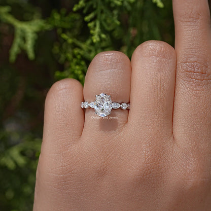 Oval moissanite ring with small round side accents, sterling silver band
