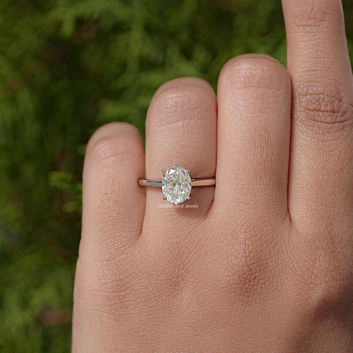 Oval moissanite solitaire ring with prong-set oval stone, slim silver band