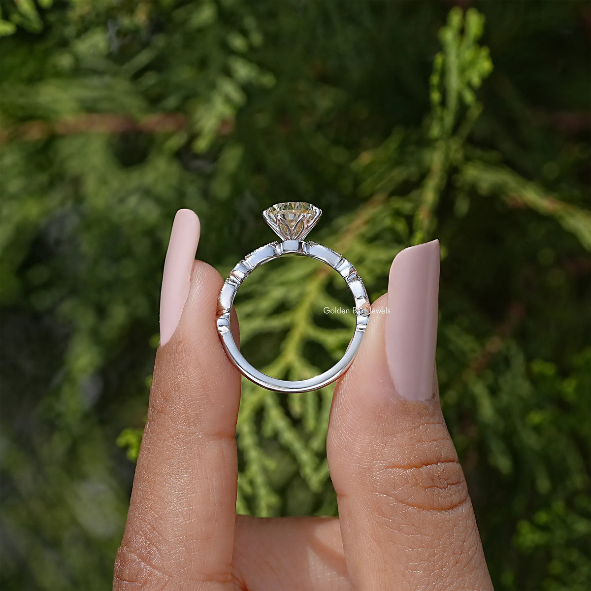 Pear-cut moissanite engagement ring in silver setting, side view