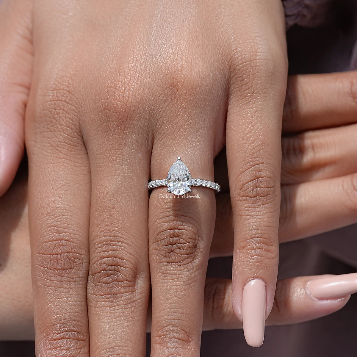 Sterling silver moissanite solitaire ring with pear-cut center and sparkling side stones