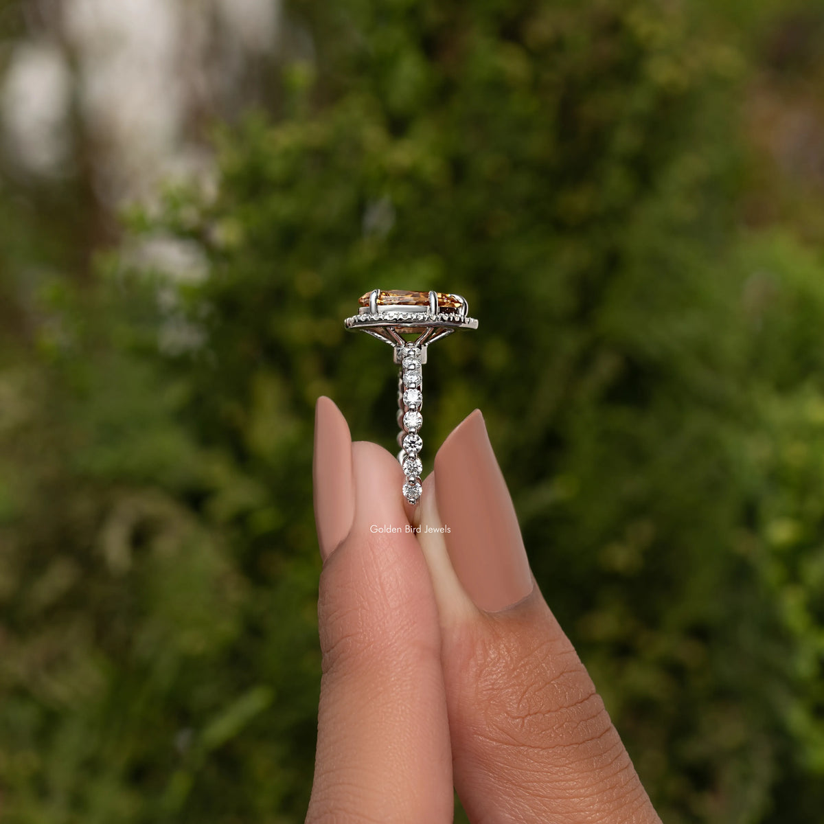 Moissanite halo engagement ring with pear-cut center stone and pavé band