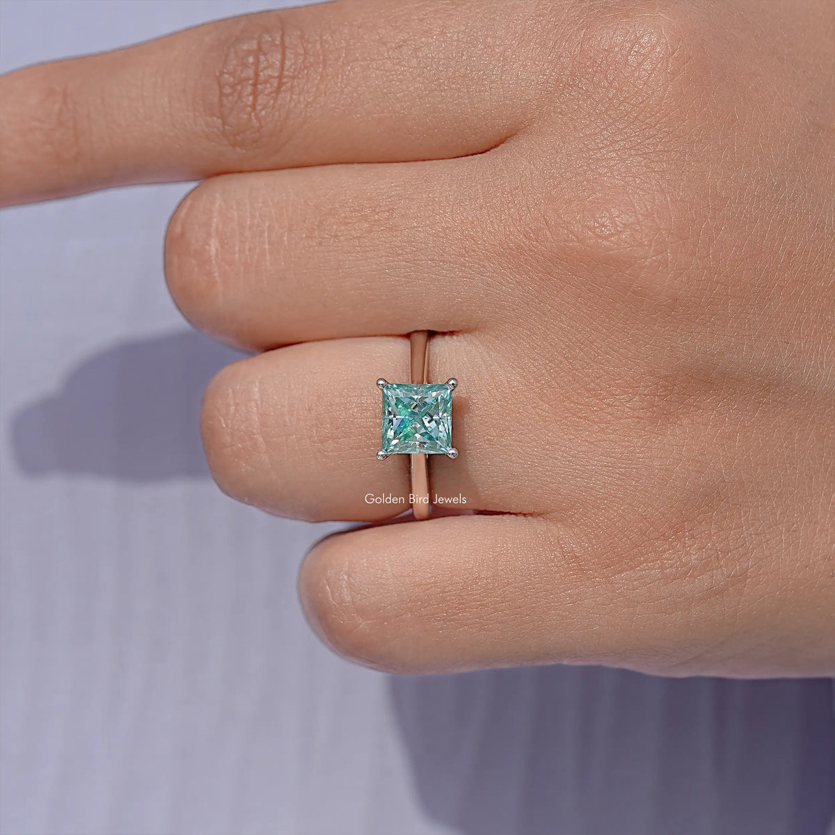 Moissanite solitaire ring with square light-blue princess-cut center stone on silver band