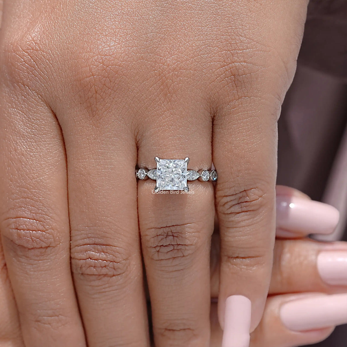 Sterling silver ring on fingers with princess-cut center stone and side sparkle accents
