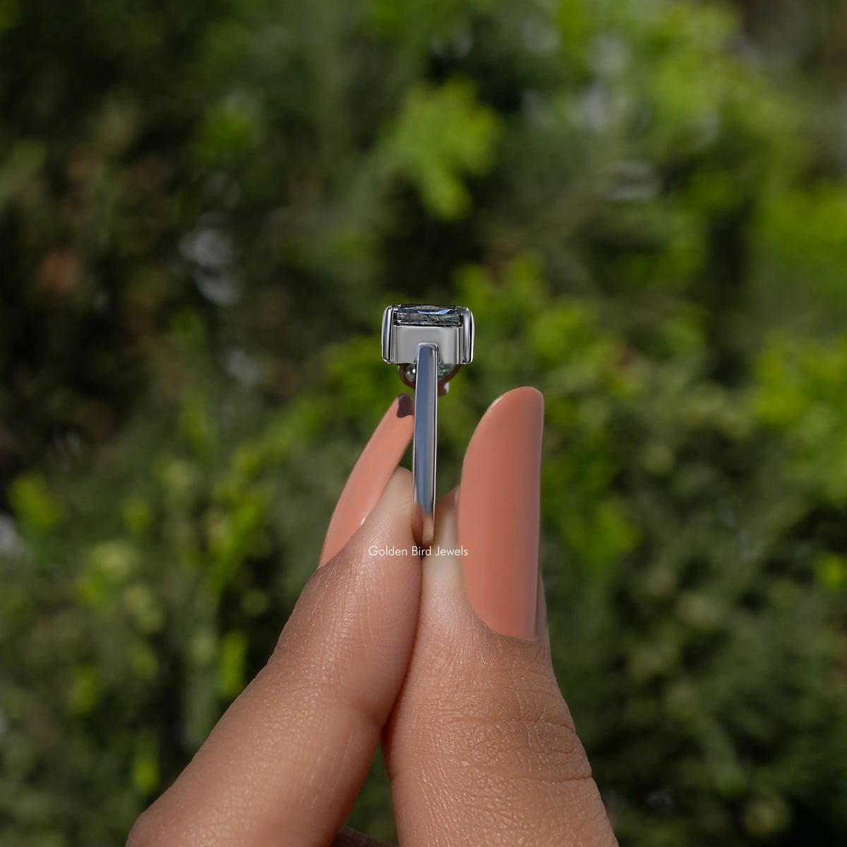 Three-stone moissanite ring side view with pronged rectangular center and side stones
