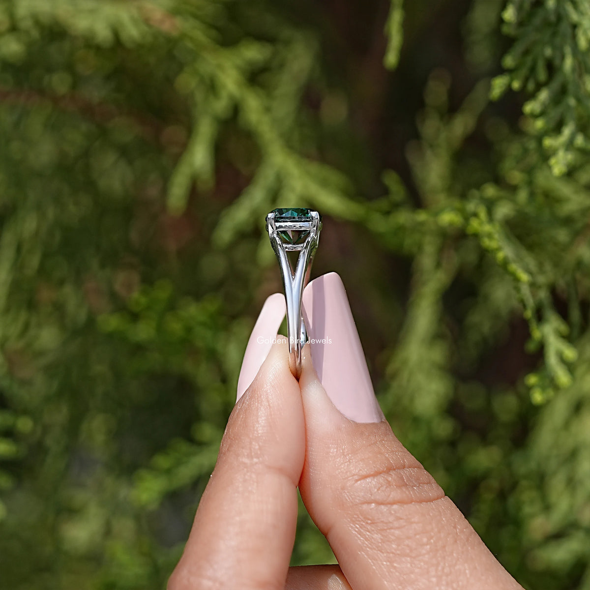Back view of sterling silver split-shank ring with round teal moissanite prongs