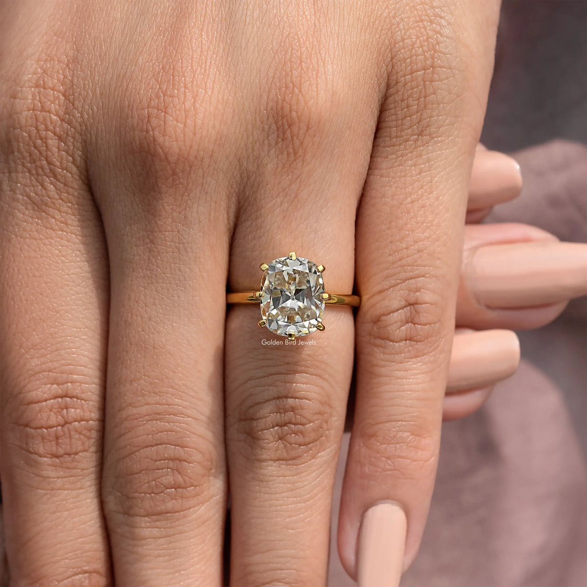 Gold-tone cushion solitaire ring with prominent square center stone and four-prong detail